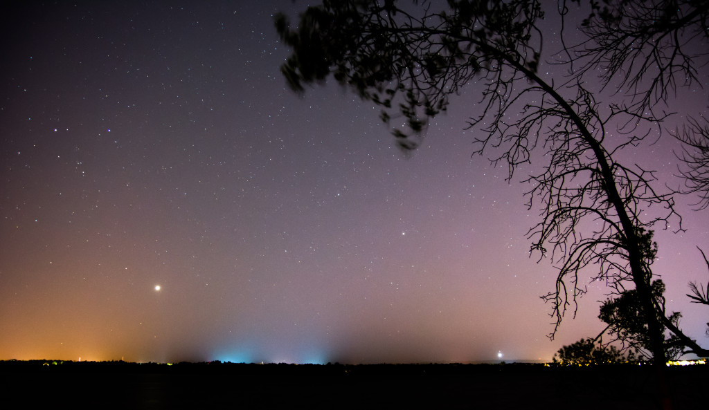 Venus setting (lower left) amid light pollution (the orange color at left) and a faint auroral display over downtown Ottawa, Canada